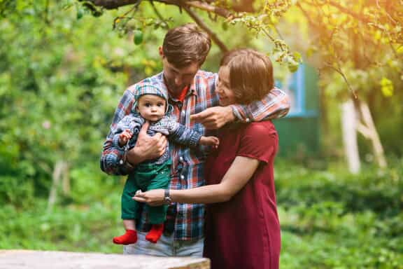 Father and mother holding baby representing adoption 